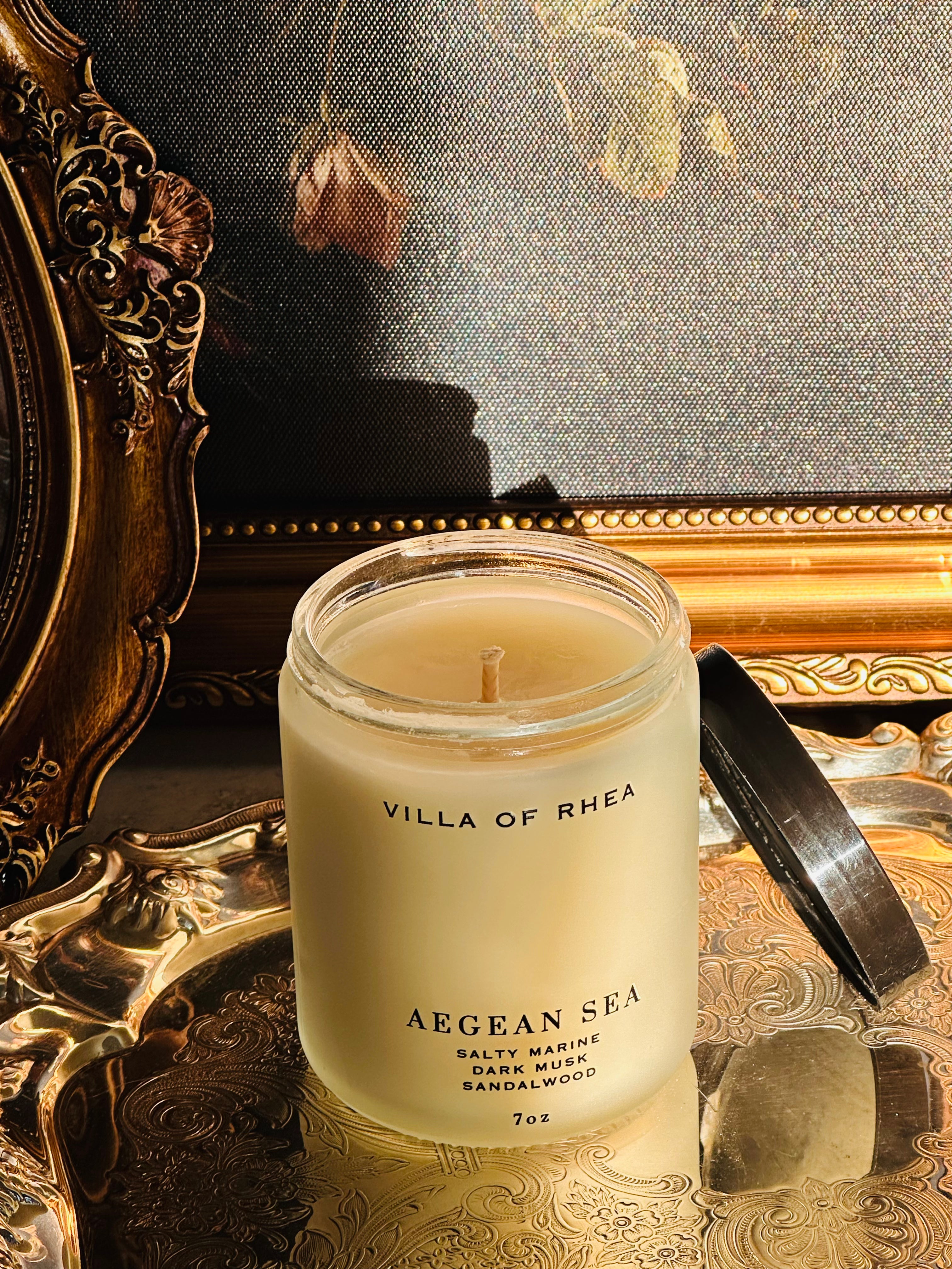 Villa of Rhea Aegean Sea candle on a reflective surface with decorative background. salty marine, dark musk, sandalwood scent. Vintage style. greek mythology inspired. luxurious soy wax candies. renaissance art. 