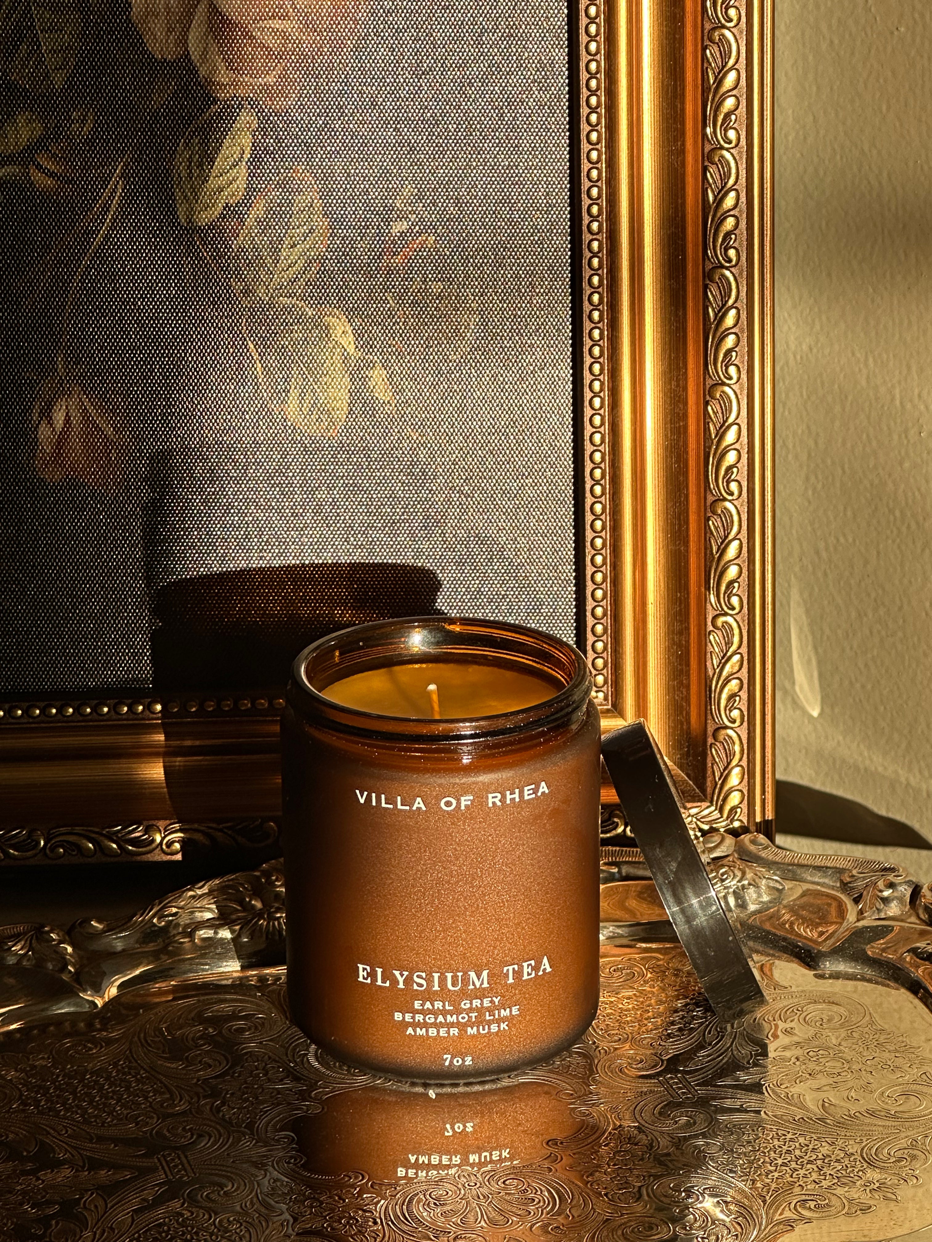 Villa of Rhea Elysium Tea candle on a reflective surface with decorative background. earl grey tea, bergamot lime, amber musk scent. Vintage style. greek mythology inspired. luxurious soy wax candies. renaissance art. 