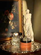 Sugar scrub named 'Aphrodite' on a reflective surface with classical sculpture in the background .Vintage style. Greek Mythology Inspired. Luxury body scrub. handmade body scrubs.