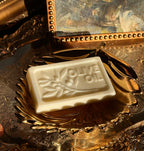 Bar of olive oil soap on a decorative gold tray with a reflective background.Vintage style. Greek Mythology Inspired. Luxury Goats milk soap