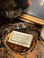 Bar of olive oil soap on a decorative gold soap dish with a reflective surface in the background. Vintage style. Greek Mythology Inspired. Luxury Goats milk soap