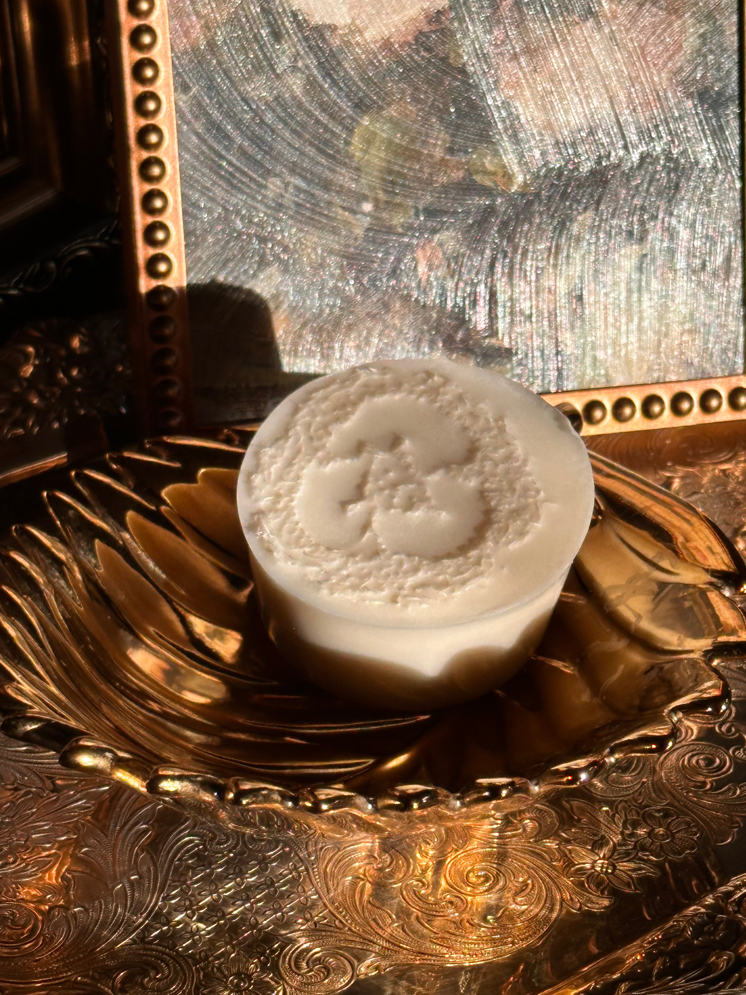 White loofa scrub goats milk soap. on a gold and silver ornate surface. Vintage style. Greek Mythology Inspired. Luxury Body OilsVintage style. Greek Mythology Inspired. Luxury Goats milk soap