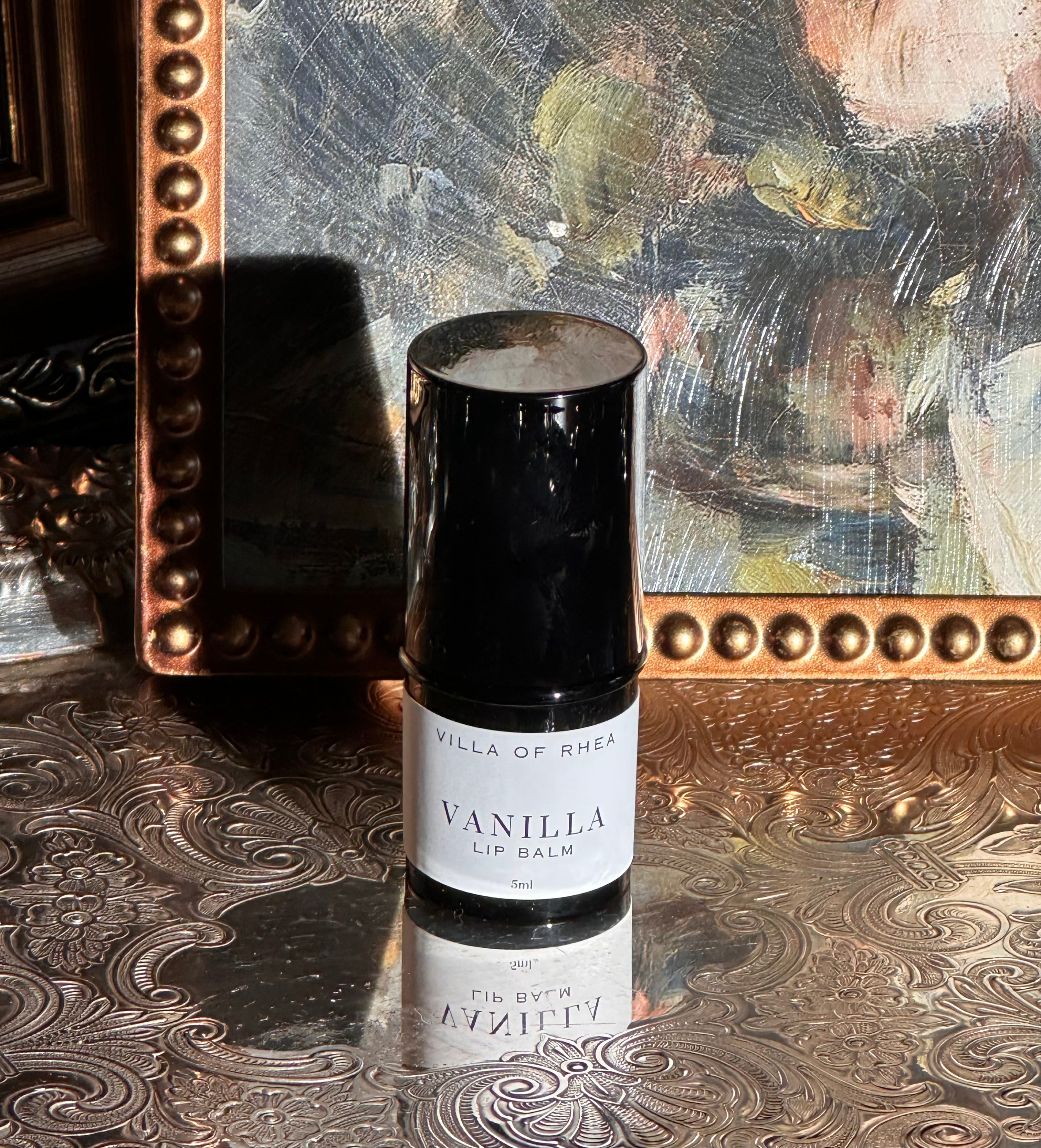 Villa of Rhea Grapefruit Lip Balm on a decorative surface with a textured background.Vintage style. Greek Mythology Inspired. Luxury lip balm. luxurious handmade lip balm