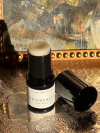 Villa of Rhea Grapefruit Lip Balm on a decorative surface with a textured background.Vintage style. Greek Mythology Inspired. Luxury lip balm. luxurious handmade lip balm