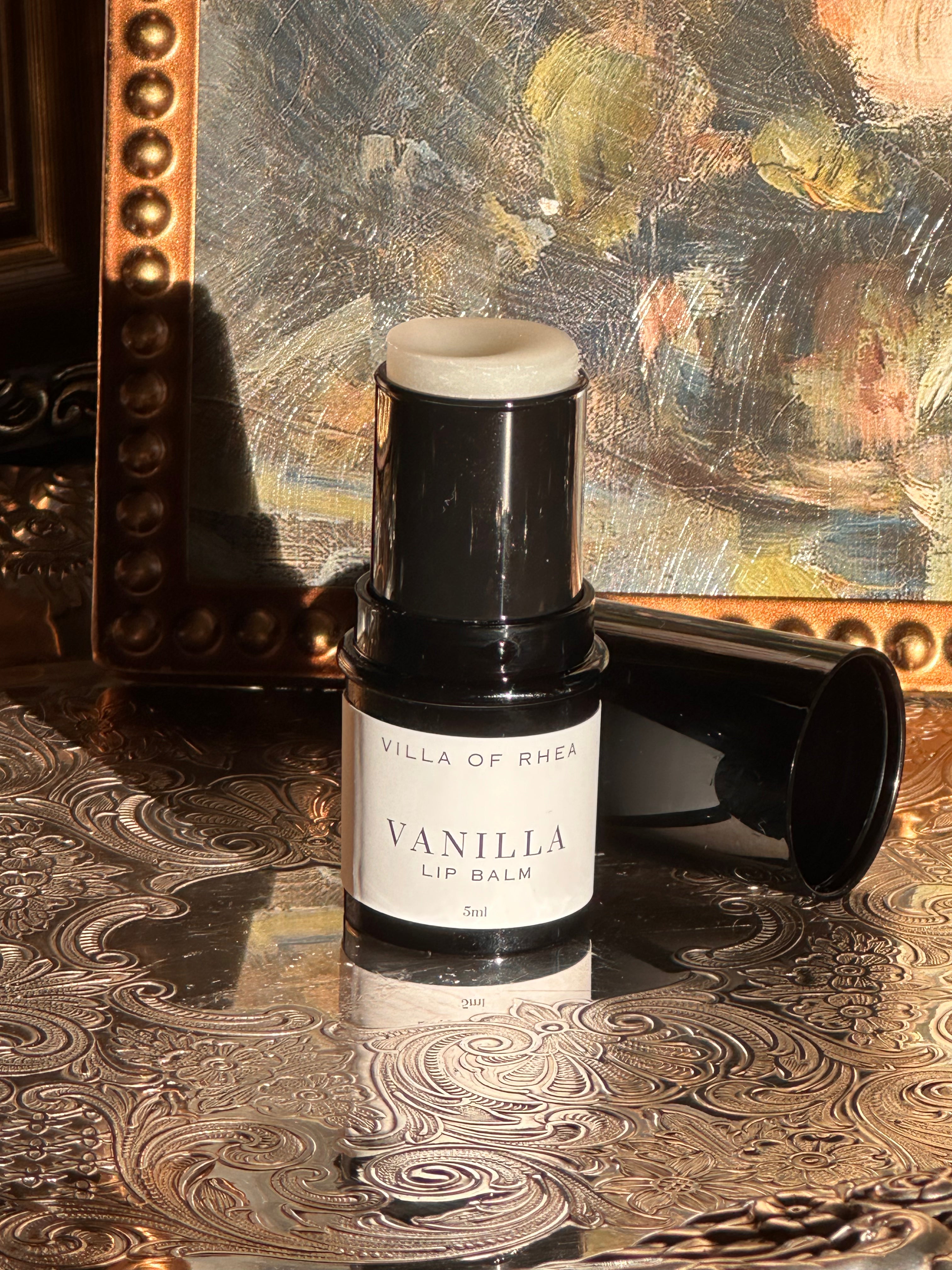 Villa of Rhea Grapefruit Lip Balm on a decorative surface with a textured background.Vintage style. Greek Mythology Inspired. Luxury lip balm. luxurious handmade lip balm