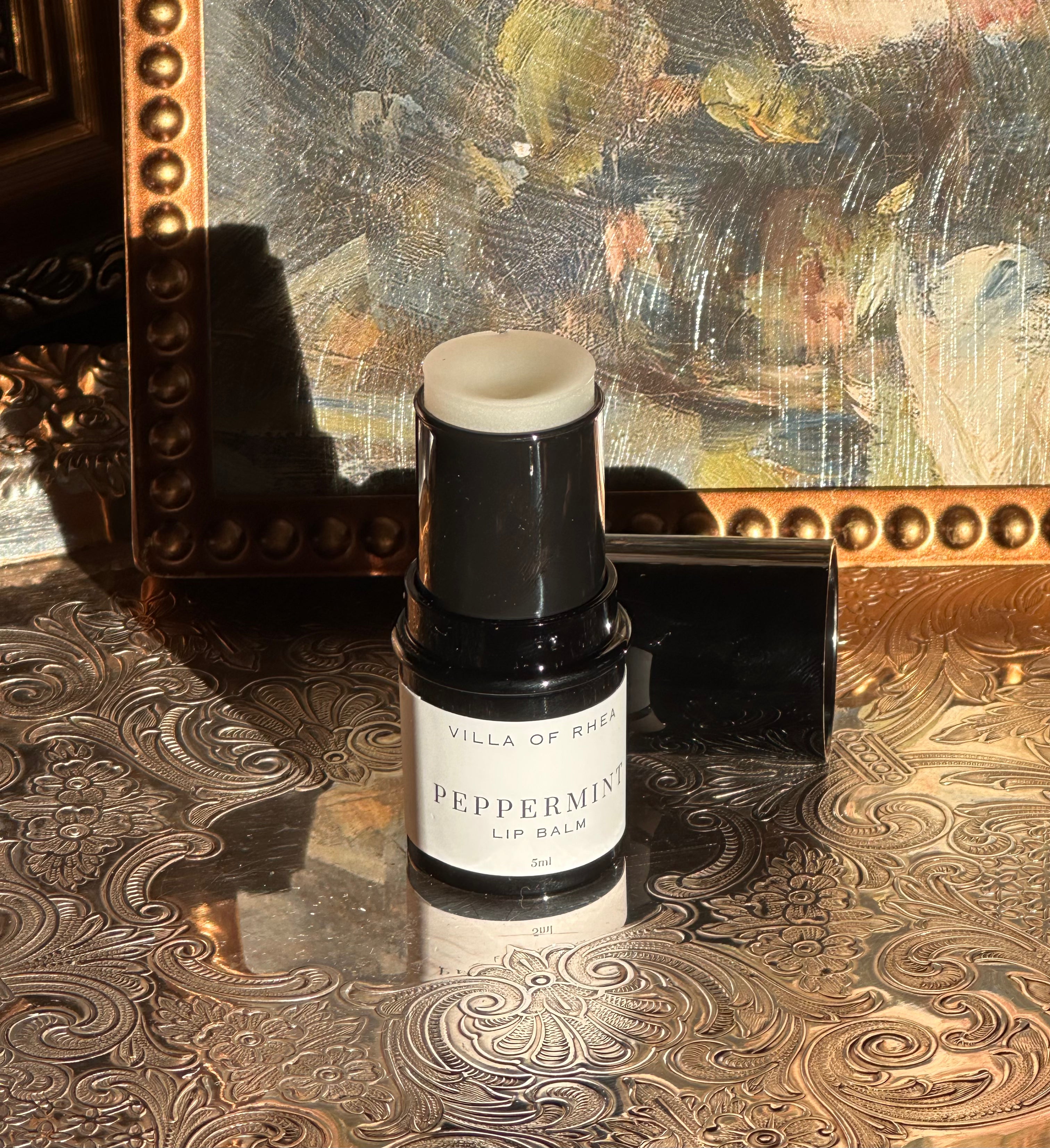 Villa of Rhea Grapefruit Lip Balm on a decorative surface with a textured background.Vintage style. Greek Mythology Inspired. Luxury lip balm. luxurious handmade lip balm