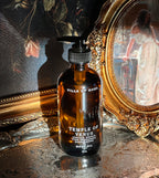 Villa of Rhea body oil bottle with classical statue and floral painting in the background.Temple of Venus Body Oil. Vanilla Scent. Orchid Scent. Hydrangea and Sandalwood Fragrance. Aphrodite Goddess. Greek Mythology inspired. Vintage Modern Style. All Natural body oil. Non-toxic Body Care. Healthy Clean Beauty. Green Beauty. Healthy Body Oil